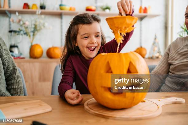 little girl carving out a pumpkin for halloween - carving craft product stock pictures, royalty-free photos & images