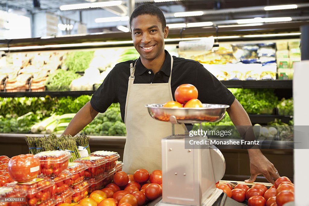 Worker weighing fruit in supermarket