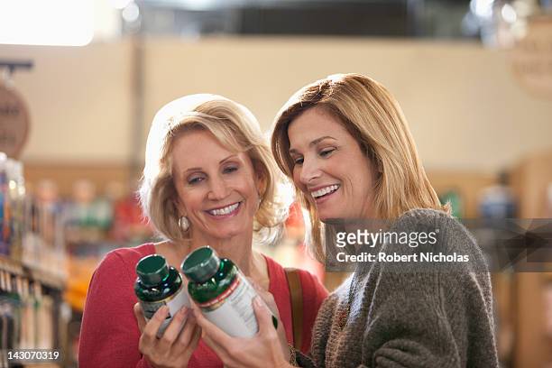 women examining supplement bottles in store - vitamin stock pictures, royalty-free photos & images