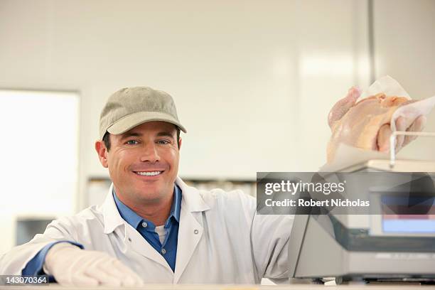 butcher weighing meat behind counter - butchery stock-fotos und bilder