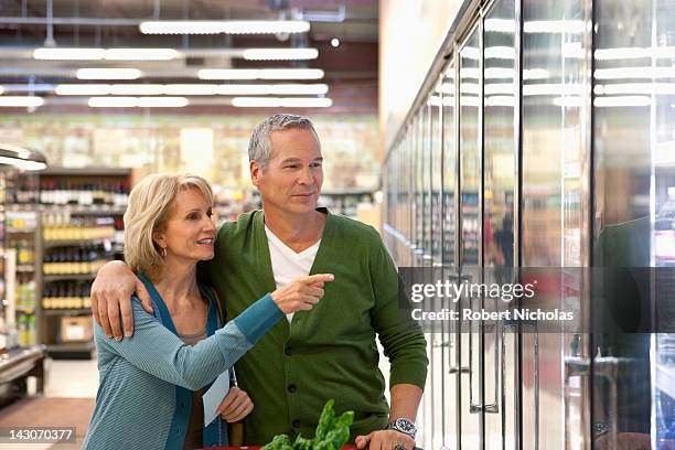older couple shopping in supermarket - couple in supermarket stock-fotos und bilder