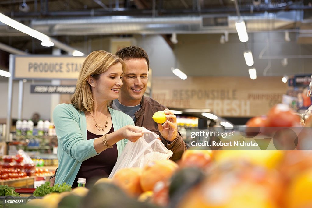 Couple examining produce in supermarket