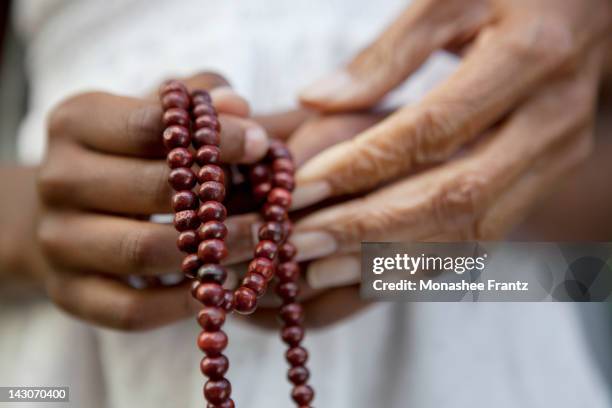 close up of hands holding beads - iglesia católica romana fotografías e imágenes de stock