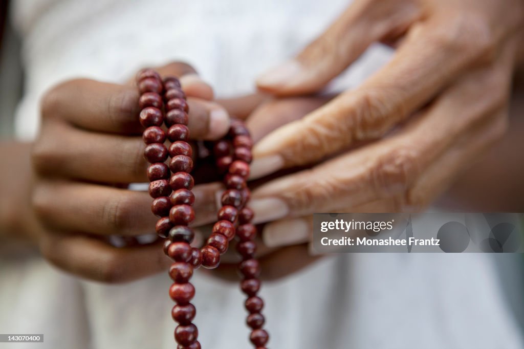 Close up of hands holding beads