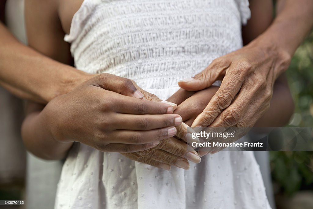 Close up of older woman and granddaughter's hands