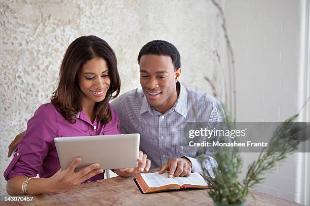 couple reading from bible and tablet - black women in the bible stock pictures, royalty-free photos & images