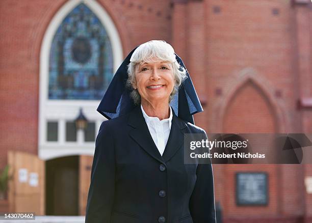 smiling nun walking outdoors - nonne stock-fotos und bilder