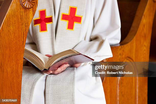 close up of priest reading bible - reverendo clerecía fotografías e imágenes de stock