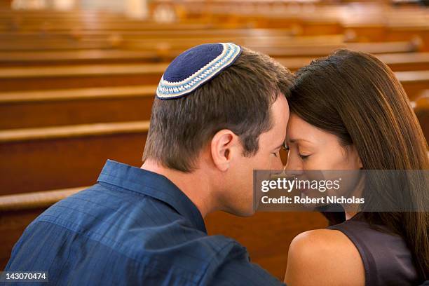 man in yarmulke praying with girlfriend - yarmulke stock pictures, royalty-free photos & images