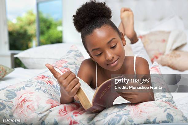 girl reading bible in bed - reading bible in bed photos et images de collection