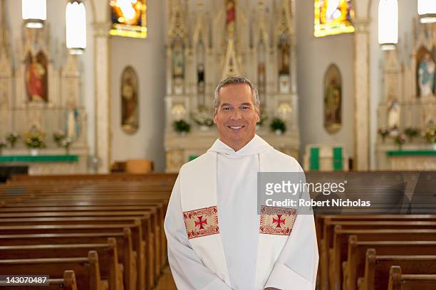 priest standing in ornate church - pastor stock pictures, royalty-free photos & images