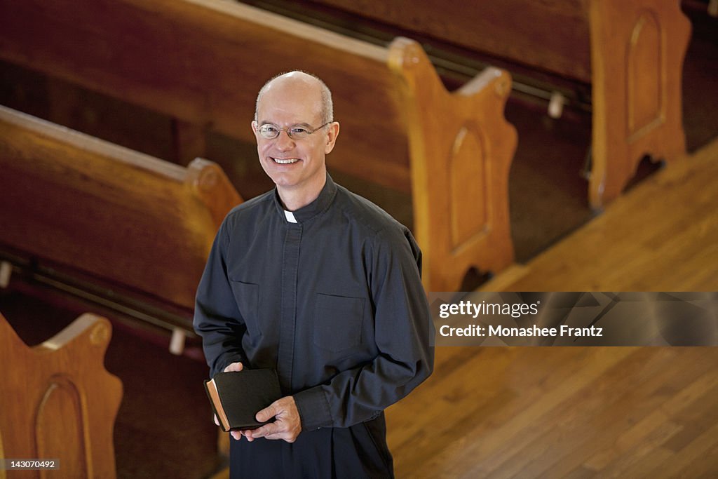 Smiling priest standing in church