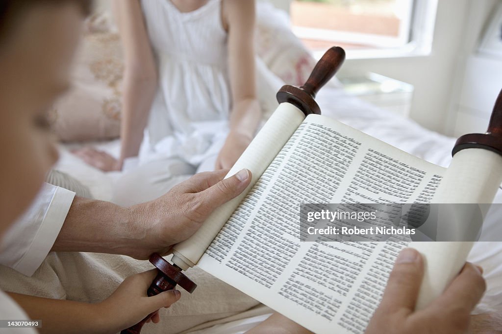 Family reading Torah scrolls together