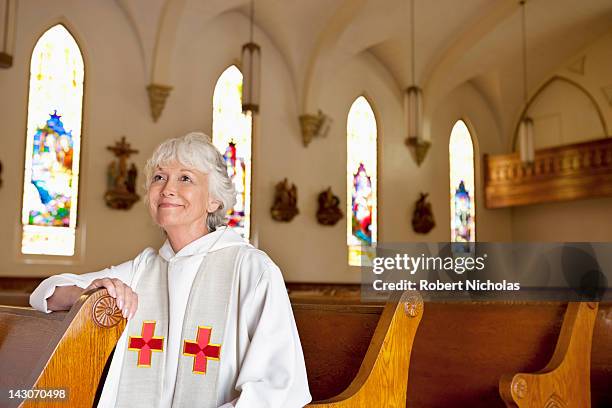 reverend sitting in church pews - priest stockfoto's en -beelden