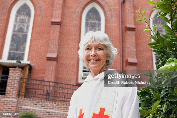 smiling reverend standing outside church - reverendo clerecía fotografías e imágenes de stock