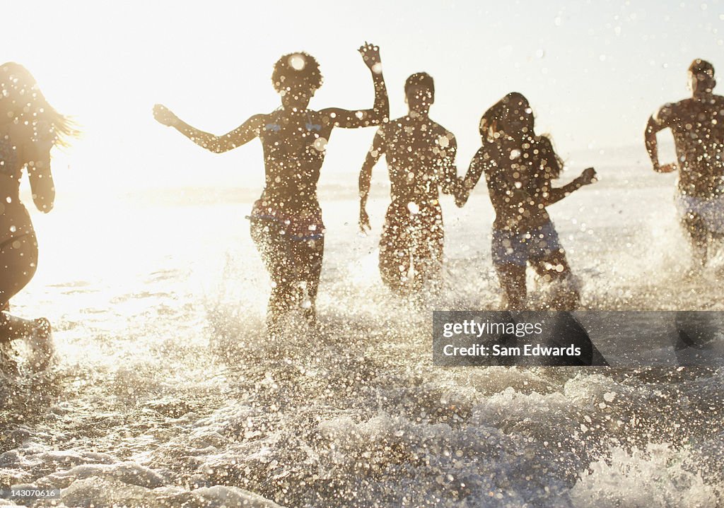 Friends playing in waves on beach