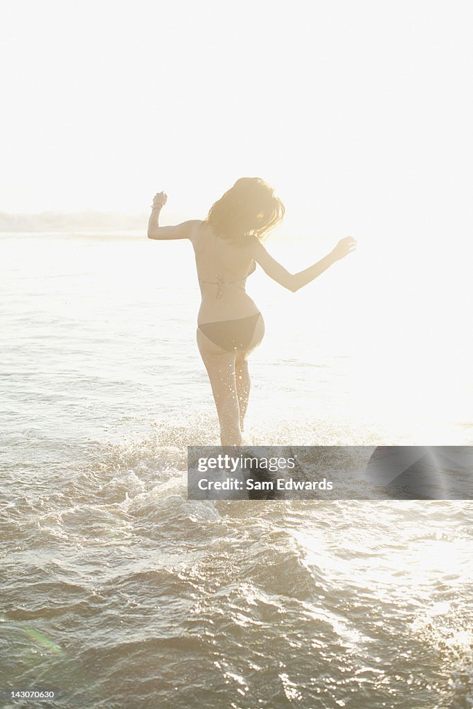 Woman walking in waves on beach