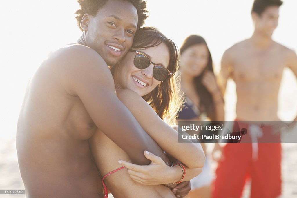 Smiling couple hugging on beach