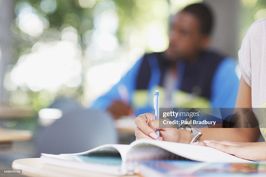 Student writing at desk