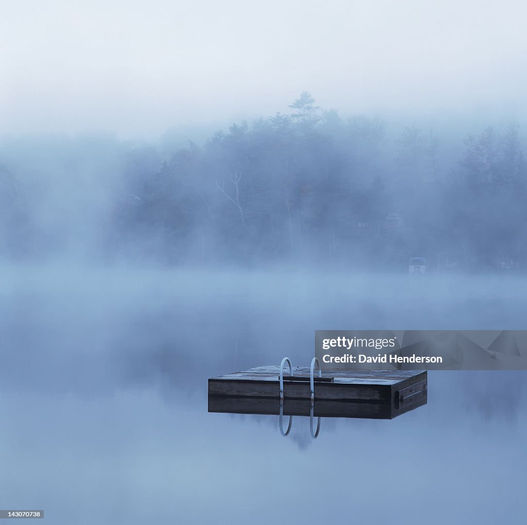 Wooden dock floating in still lake