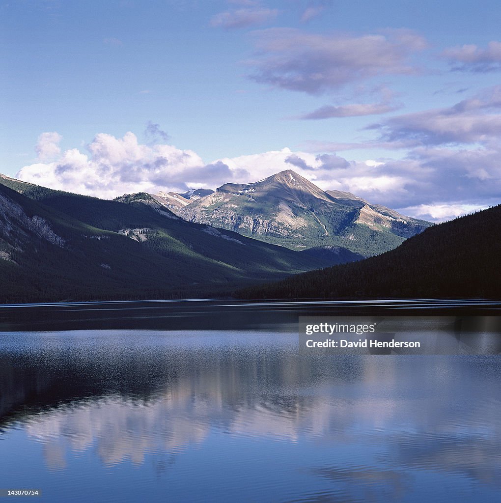 Rocky mountains and sky reflected in still lake