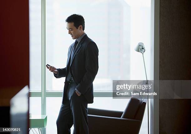 businessman using cell phone in office - samuser stock pictures, royalty-free photos & images