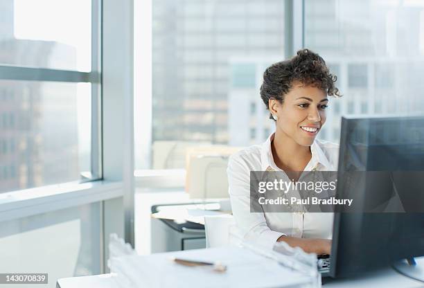 businesswoman working at desk in office - computers pc stockfoto's en -beelden