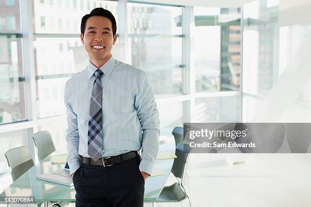 homme d'affaires souriant, debout dans le bureau - chemise et cravate photos et images de collection