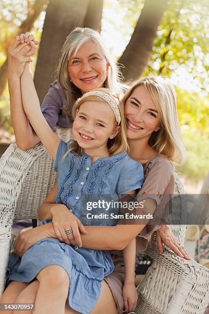 three generations of women sitting together - granny chair stock pictures, royalty-free photos & images