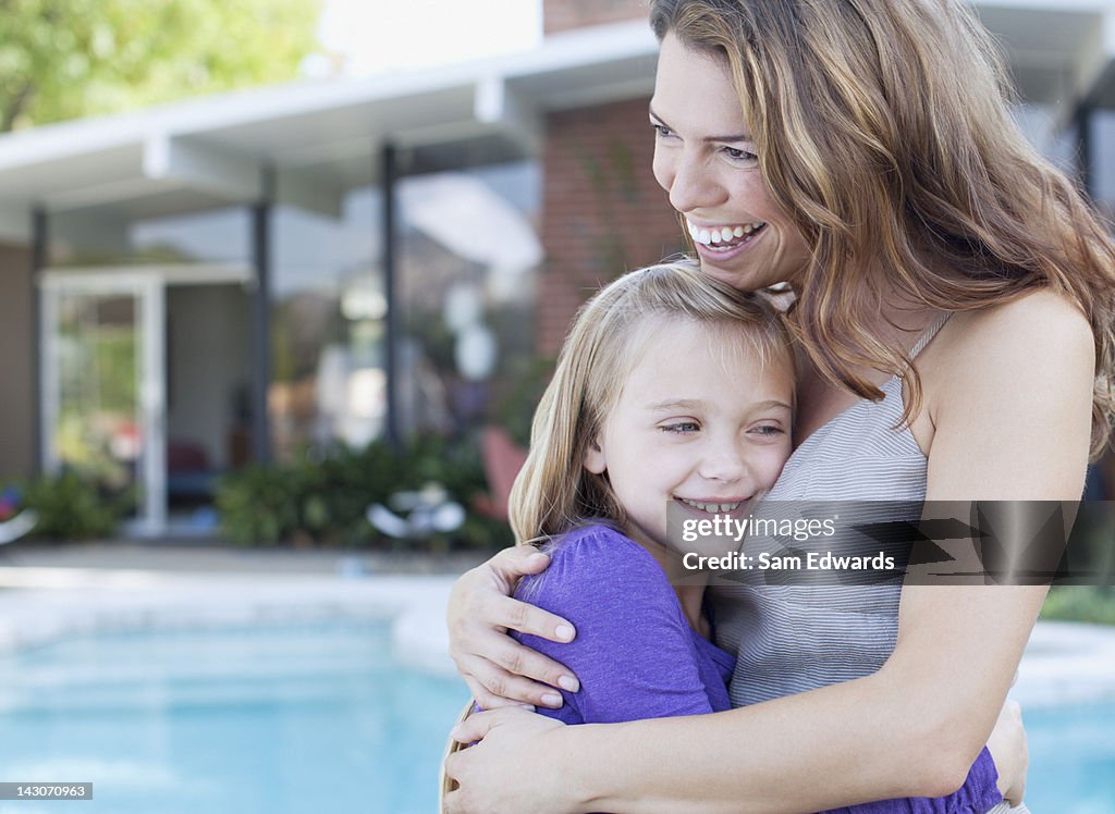 Mother and daughter hugging outdoors