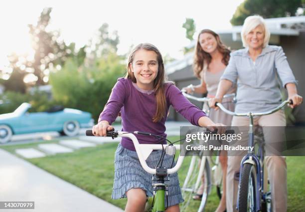 drei generationen von frauen auf fahrrädern - fahrrad fahren großeltern mit kind stock-fotos und bilder