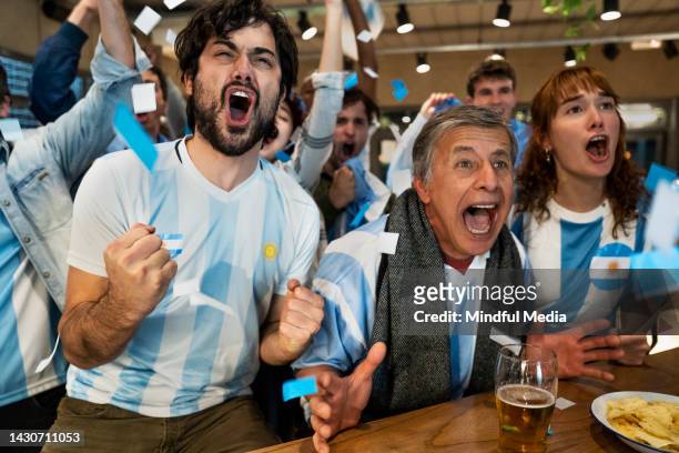 aficionados deportivos argentinos gritan y animan a la selección nacional en el bar deportivo - argentino fotografías e imágenes de stock