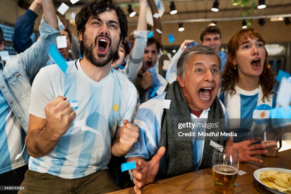 Tifosi sportivi argentini che gridano e tifano per la squadra nazionale al bar dello sport