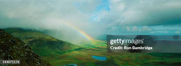 rainbow stretching over rural landscape - landscap with rainbow fotografías e imágenes de stock