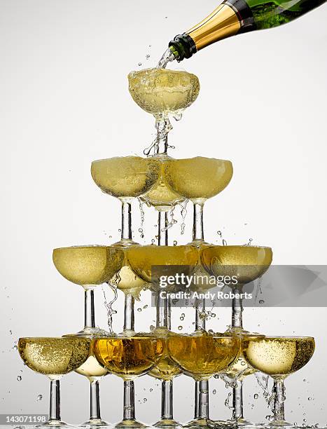 champagne pouring into stacked glasses - overflowing glass stock-fotos und bilder