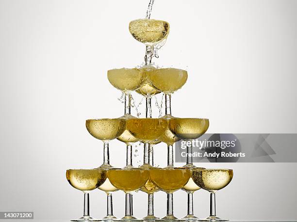 champagne pouring into stacked glasses - champagne pyramid stock pictures, royalty-free photos & images