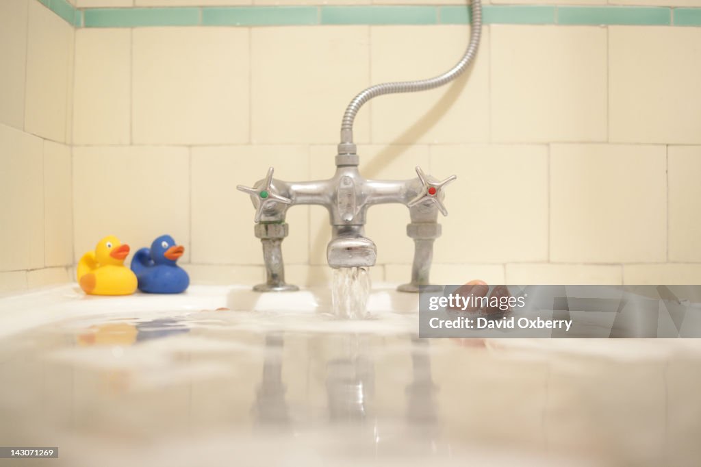 Faucet pouring water into bath tub