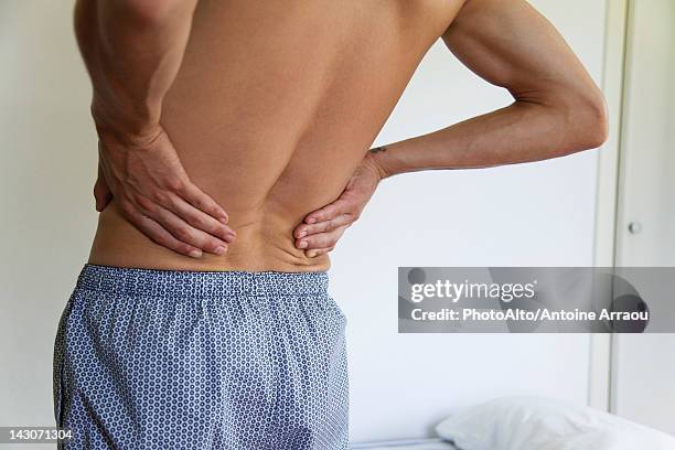 man experiencing lower back pain, cropped - 下背部痛 個照片及圖片檔