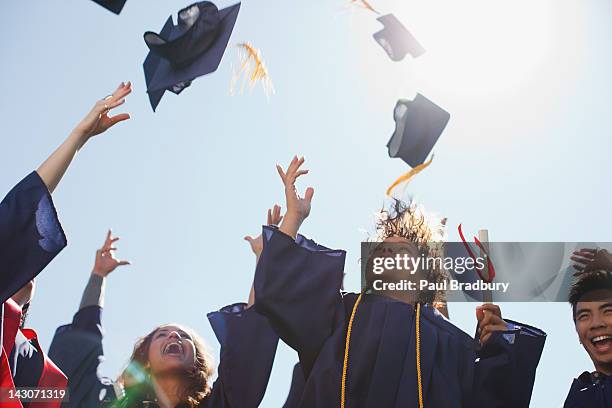graduates tossing caps into the air - graduation celebration stock pictures, royalty-free photos & images