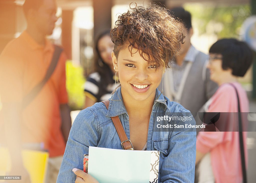 Smiling student carrying folder