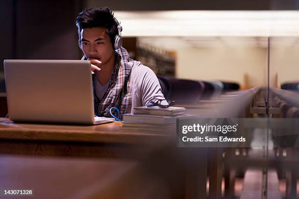 estudiantes trabajando en el ordenador portátil en la biblioteca - enfoque fotografías e imágenes de stock