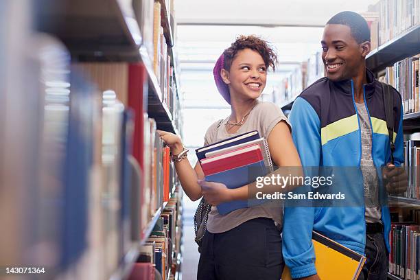 students talking in library - couple school stockfoto's en -beelden