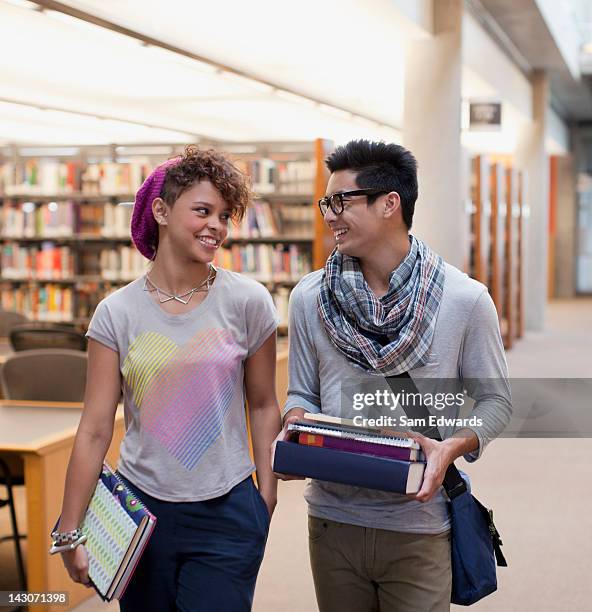 lächelnd studenten sprechen in der bibliothek - two men studying library stock-fotos und bilder