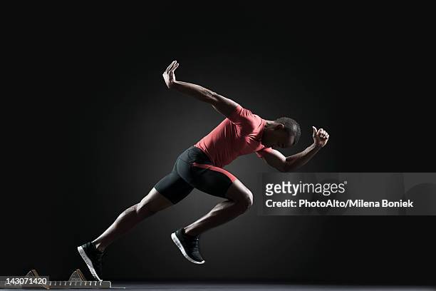 male athlete leaving starting block - sprint start stock-fotos und bilder