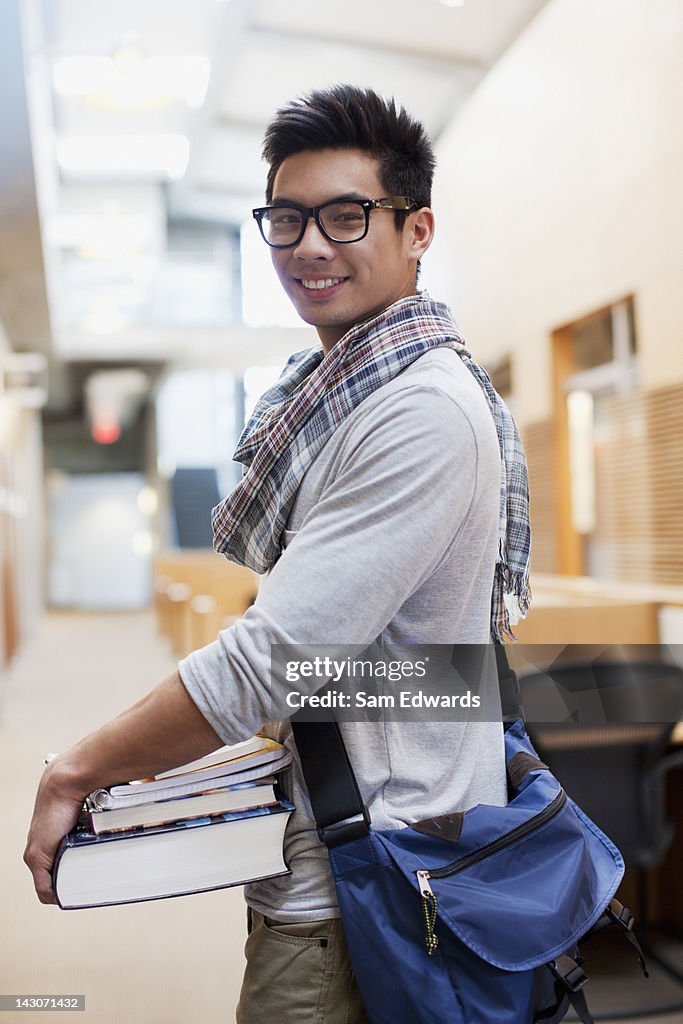 Student carrying books in school hallway
