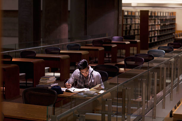 student working in library at night - assignment stock pictures, royalty-free photos & images