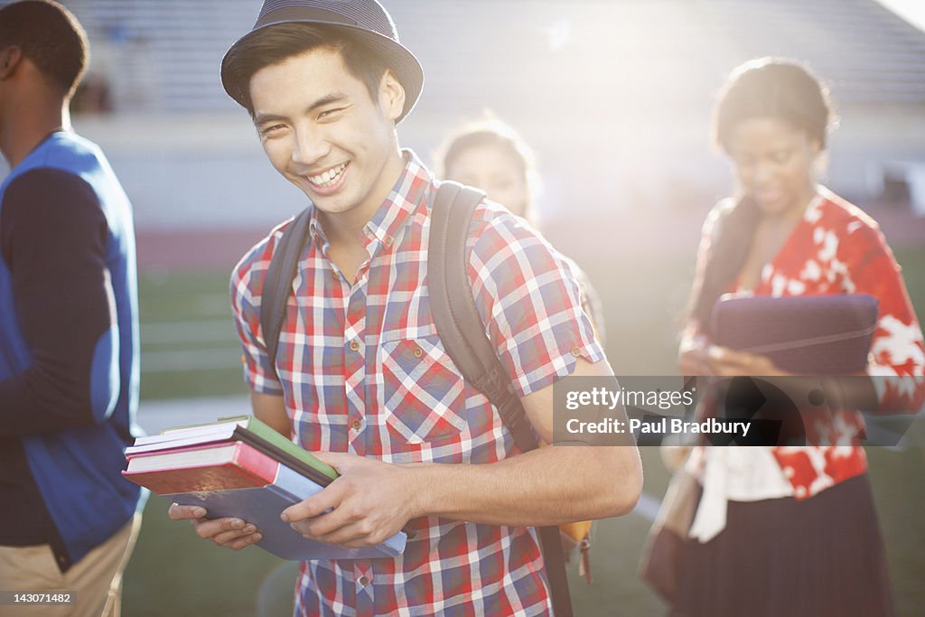 Student carrying books outdoors