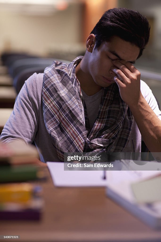 Tired student at work in library