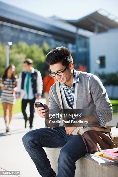 smiling student using cell phone outdoors - filipino woman smiling stock pictures, royalty-free photos & images