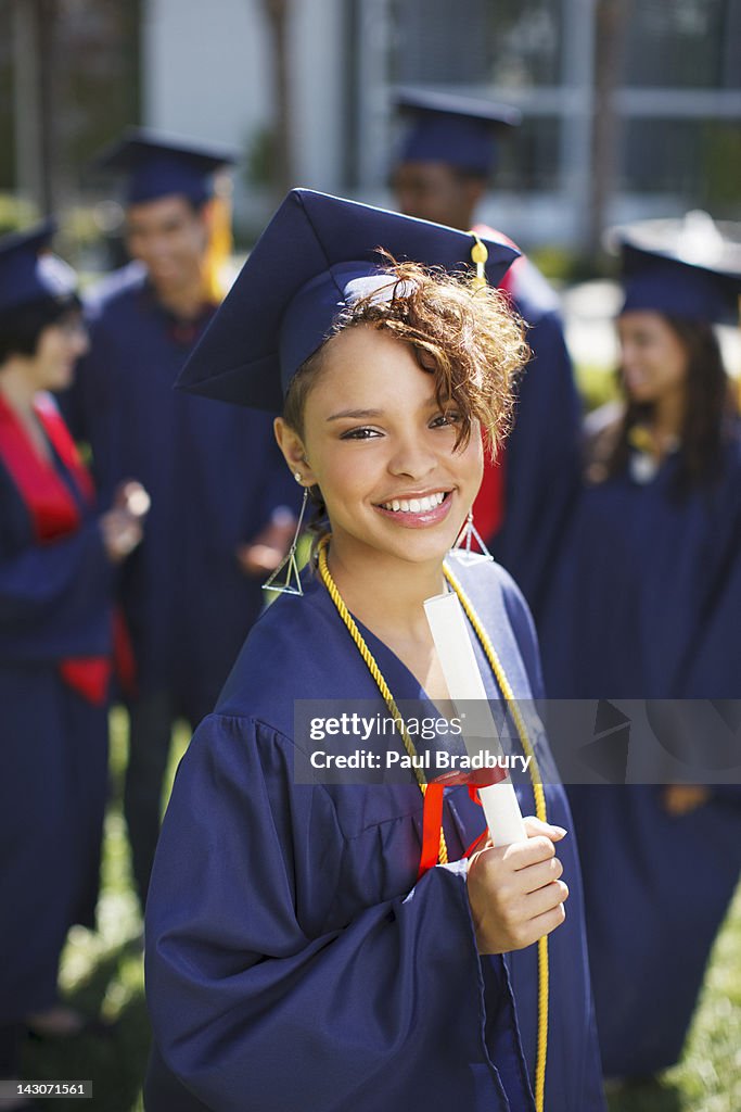 Smiling graduate holding diploma